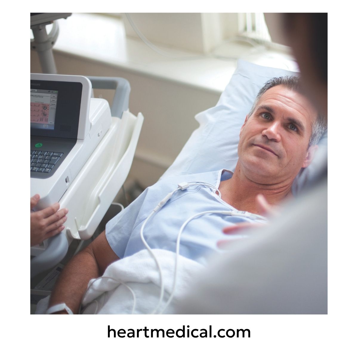 Clinician using a Philips EKG machine at a patient’s bedside for point-of-care data.